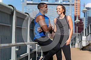 Portrait of a fit athletic sporty couple posing during their summer day jog in urban city background
