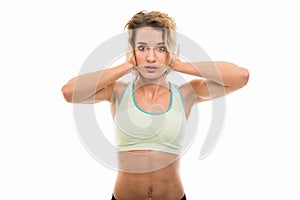 Portrait of fit girl covering ears like deaf gesture