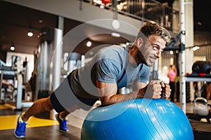 Portrait of fit handsome man workout on a fitness machine at gym