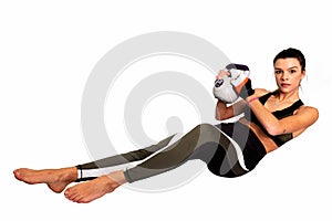 Portrait of a fit health woman doing intense core workout with kettlebell . Image