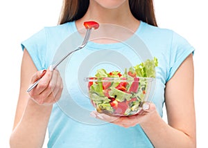 Portrait of a fit healthy woman eating a fresh salad isolated