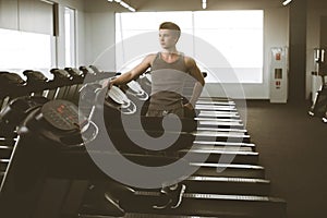 Portrait of a fit man in sportswear standing beside a treadmills in a gym. Active Lifestyle. Getting Better. Gym