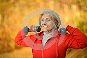Portrait of fit senior woman exercising with dumbbells