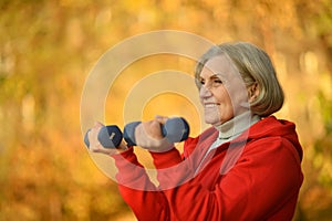 Portrait of fit senior woman exercising with dumbbells