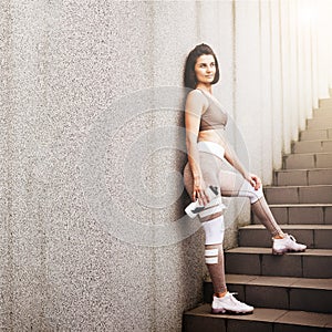 Portrait of fit and sporty young woman doing exercises of stretching, yoga or pilates in the early morning park