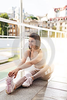 Portrait of fit and sporty young woman doing exercises of stretching, yoga or pilates in the early morning park