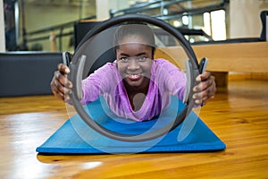 Portrait of fit woman exercising with pilates ring in fitness studio