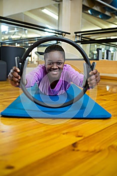 Portrait of fit woman exercising with pilates ring in fitness studio