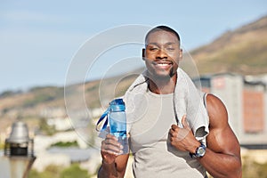 Portrait, fitness and water bottle with a sports black man or runner standing outdoor with a towel during exercise