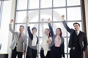 Portrait of five cheerful happy businesspeople, group of businessmen and businesswomen confident raising hands up to celebrate