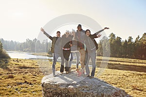 Portrait of five friends standing on a rock in countryside