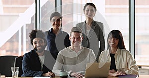 Portrait of five multiethnic ambitious startuppers pose in modern office