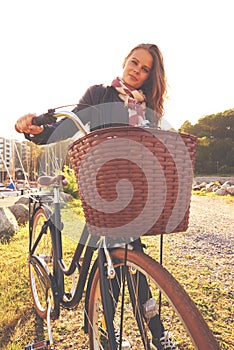 Portrait, flare and a girl with her bicycle in the park for travel, freedom or eco friendly adventure. Summer, cycling