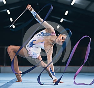 Portrait of flexible woman, ribbon gymnastics and dance for performance, sports competition and action show. Female