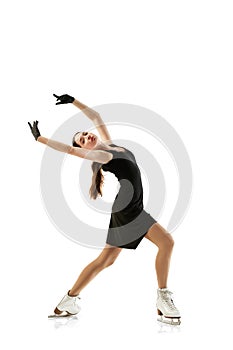 Portrait of flexible young girl, female figure skater in black stage costume skating isolated over white background