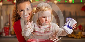 Portrait of flour smeared mother and baby making cookies