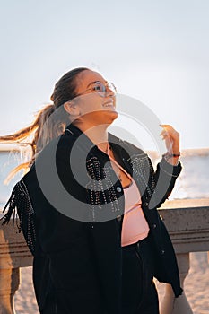 Portrait focus shot of a cheerful Caucasian female with glasses  smiling on sunny day