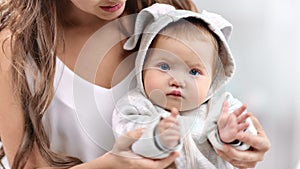 Portrait of focused cute baby wearing white clothes clapping hand looking at camera close-up