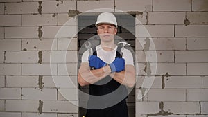 Portrait of foreman at a construction site with hammer and a wrench in his hands