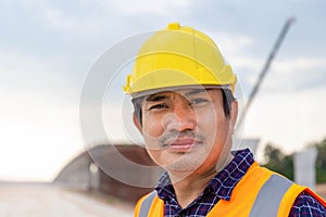 Portrait of Foreman worker in hardhat at the infrastructure construction site, Construction engineer checking project at the