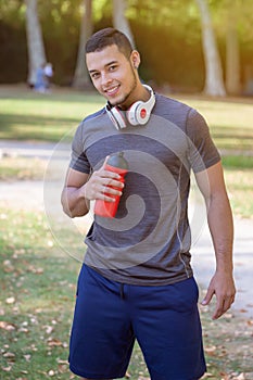 Portrait format runner smiling young latin man running jogging sports training fitness workout
