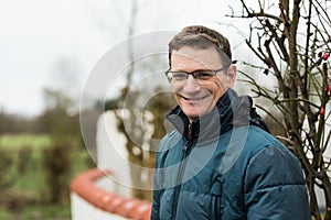 Portrait of a forty year old handsome man with glasses posing at the Belgian countryside