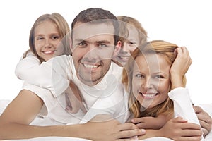 Portrait of four caucasian family members lying down in white cl