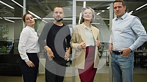Portrait of four office workers with their arms crossed on their chests. Slow motion.