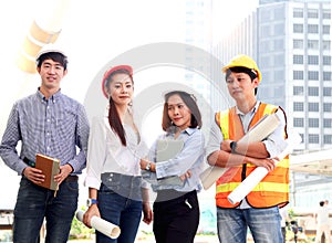 Portrait of four smart young Asian man and woman engineer group, staff worker team wear safety vest and helmet, confidential