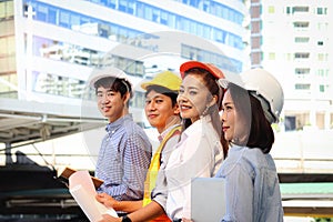 Portrait of four smart young Asian man and woman engineer group, staff worker team wear safety vest and helmet, confidential