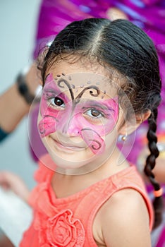 Portrait of a four year old cute pretty girl child young with her face painted for fun at a birthday party