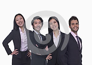Portrait of four young business people looking at the camera, three quarter length, studio shot