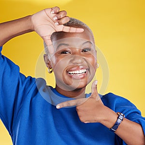 Portrait, frame and hand gesture with a black woman in studio on a yellow background feeling happy. Hands, smile and