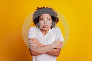 Portrait of freezing woman hands cuddle shoulders tremble on yellow background