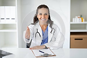 Portrait of friendly attractive mature woman doctor in clinic