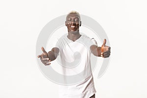 Portrait of friendly handsome african-american blond man, reaching hands to hold something, hugging you, standing white