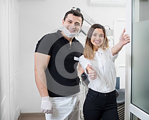 Portrait of friendly male dentist with happy female patient after treatment in modern dental office. Dentistry