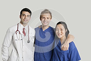 Portrait of friendly medical team standing over gray background