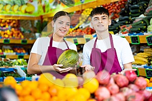 Portrait of friendly salespeople in fruit section of grocery store photo