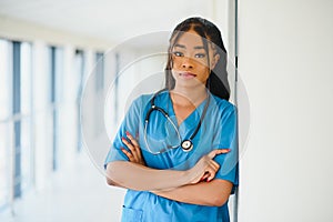 Portrait of friendly, smiling confident female healthcare professional with lab coat, arms crossed holding glasses. 