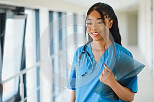 Portrait of friendly, smiling confident female healthcare professional with lab coat, arms crossed holding glasses. Isolated