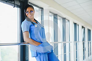 Portrait of friendly, smiling confident female healthcare professional with lab coat, arms crossed holding glasses. Isolated