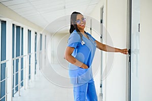 Portrait of friendly, smiling confident female healthcare professional with lab coat, arms crossed holding glasses. Isolated