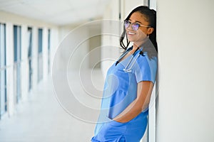 Portrait of friendly, smiling confident female healthcare professional with lab coat, arms crossed holding glasses. Isolated