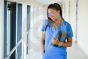 Portrait of friendly, smiling confident female healthcare professional with lab coat, arms crossed holding glasses. Isolated