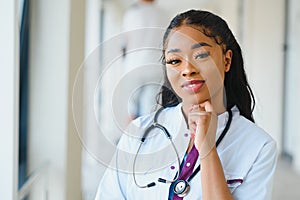 Portrait of friendly, smiling confident female healthcare professional with lab coat, arms crossed holding glasses. Isolated