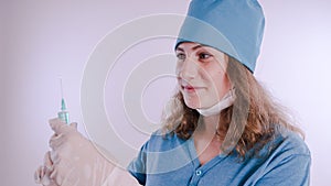 Portrait of a friendly smiling doctor woman or nurse in white medical uniform with a syringe, on white background with co