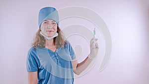 Portrait of a friendly smiling doctor woman or nurse in white medical uniform with a syringe, on white background with co