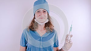 Portrait of a friendly smiling doctor woman or nurse in white medical uniform with a syringe, on white background with co