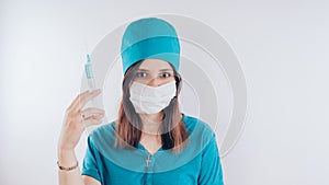 Portrait of a friendly smiling doctor woman or nurse in white medical uniform with a syringe, on white background with co